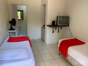 a room with two beds and a tv in it at Hotel economic eldorado in Sorocaba