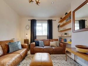 a living room with two leather couches and a table at Pass the Keys Centrally located Victorian terrace Free parking in Cambridge
