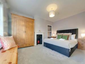 a bedroom with a large bed and a fireplace at Pass the Keys Centrally located Victorian terrace Free parking in Cambridge