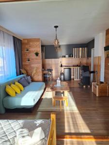 een woonkamer met een blauwe bank en een tafel bij Mrdja Apartments in Kolašin