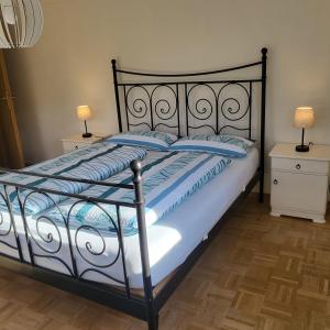 ein Bett mit einem schwarzen Rahmen und blauen Kissen in der Unterkunft Gästehaus Bruch in Kaisersbach