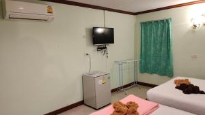 a room with two beds and a tv on the wall at Lee-view Wangnamkeaw in Wang Nam Khieo