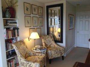 salon z 2 krzesłami i lustrem w obiekcie Belle Maison Auprès De La Mer w mieście Sidney