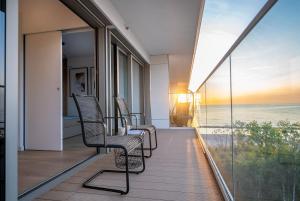 a balcony with chairs and a view of the ocean at Solaris 711, sea view. in Darłowo