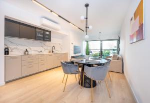 a kitchen and dining room with a table and chairs at Solaris 711, sea view. in Darłowo