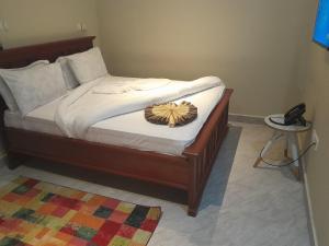 - un lit avec un cadre en bois et un chapeau dans l'établissement PALAZZO GARDEN RESORT MATEMA, à Kyela