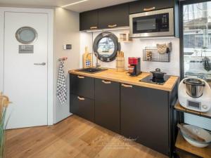 a kitchen with a sink and a microwave at Houseboat Seahorse in Heiligenhafen