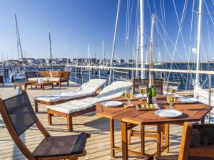 a wooden deck with tables and chairs on a yacht at Houseboat gray seal in Heiligenhafen