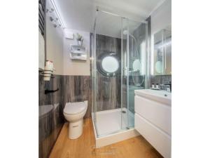 a bathroom with a shower and a toilet and a sink at Houseboat Seahorse in Heiligenhafen