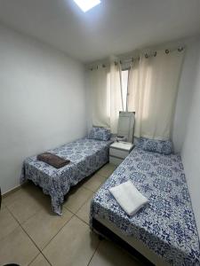 a bedroom with two beds and a tv in it at Apartamento do Sossego in São Luís