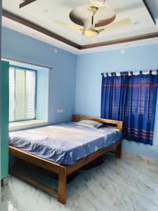 ein Schlafzimmer mit einem Bett und einem Deckenventilator in der Unterkunft Ichhepuron in Shānti Niketan