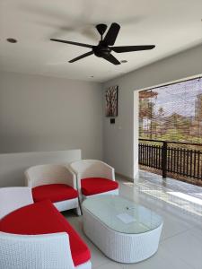 sala de estar con ventilador de techo, mesa y sillas en Villa Lovecho, en Canggu
