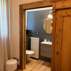 a bathroom with a toilet and a sink and a mirror at Piccolo gioiello di montagna in Villanova
