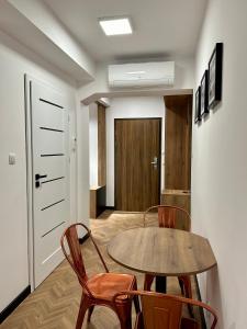 jadalnia z drewnianym stołem i krzesłami w obiekcie Apartamenty Planeta 212 Mielno centrum 100 m do morza w mieście Mielno