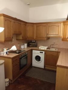 a kitchen with wooden cabinets and a white dishwasher at Rochester Corner in Rochester