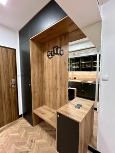kuchnia z drewnianą ścianą z ławką w obiekcie Apartamenty Planeta 212 Mielno centrum 100 m do morza w mieście Mielno