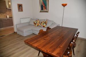 un soggiorno con tavolo in legno e divano di B&B Pavia Centro Ticino a Pavia
