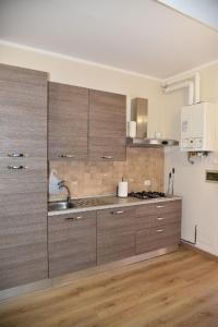 a kitchen with wooden cabinets and a sink at B&B Pavia Centro Ticino in Pavia