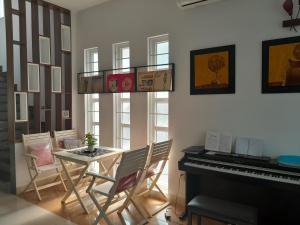 a dining room with a table and a piano at QV Home in Ho Chi Minh City