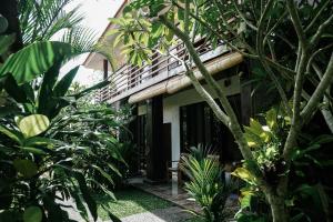 a guest house in the middle of a garden at Olas homestay bali in Uluwatu