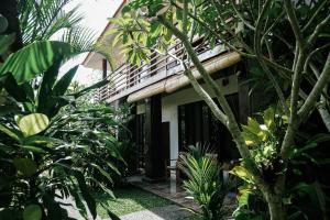 un hostal en medio de un jardín en Olas homestay bali, en Uluwatu