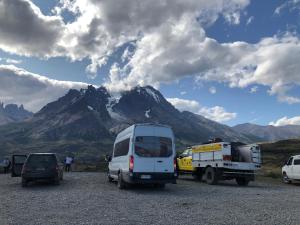 Casa central en Punta Arenas في بونتا أريناس: مجموعة سيارات تقف أمام جبل