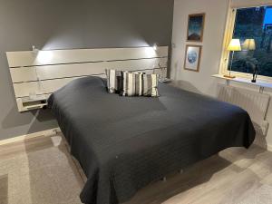 a bedroom with a large black bed with pillows at Guesthouse centrally in Vetlanda in Vetlanda