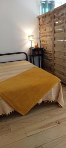um quarto com uma cama e uma mesa com um candeeiro em L’Oiseau rêveur em Darbres