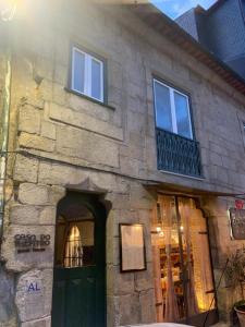 バルセロスにあるCasa do Theatro Guest Houseの緑のドアと窓のある石造りの建物