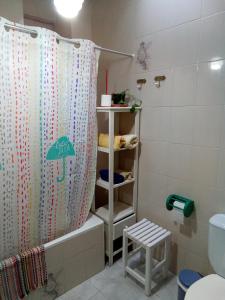 een badkamer met een douchegordijn en een toilet bij El rinconcito in Fuenteheridos