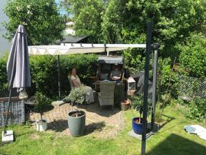 a woman sitting under an umbrella in a garden at Zentrale ruhige 3-Zimmer-Wohnung in Kassel
