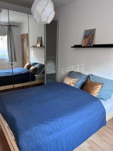 una camera con letto blu e specchio di HB Downtown Sunny Apartman a Budapest