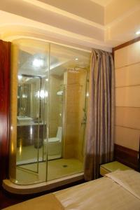 a bathroom with a glass shower with a tub at Airport GoldenTulip Hotel in Lagos