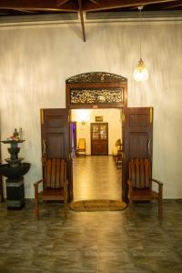 a room with two chairs and an open door at Sea Turtles Bungalow in Bentota