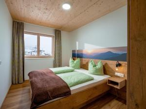 Un dormitorio con una cama grande con almohadas verdes. en M&M Appartements Brixental, en Westendorf 34 fotos más