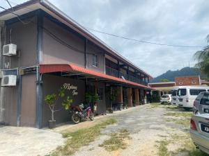 un edificio con una motocicleta estacionada frente a él en OYO 90910 Homestay D Lalang Inn, en Kuah