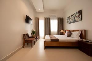 - une chambre avec un lit, une chaise et une fenêtre dans l'établissement Ngọc Châu Hotel, à Hô-Chi-Minh-Ville
