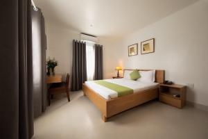 Cette chambre comprend un lit, un bureau et une fenêtre. dans l'établissement Ngọc Châu Hotel, à Hô-Chi-Minh-Ville