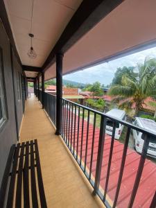 un balcón de una casa con un banco en OYO 90910 Homestay D Lalang Inn, en Kuah