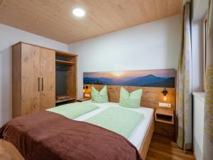 Un dormitorio con una cama grande con almohadas verdes. en M&M Appartements Brixental, en Westendorf