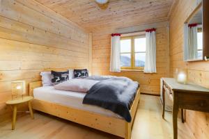 1 dormitorio con 1 cama en una cabaña de madera en Ski-in & Ski-out out Chalet Maria with amazing mountain view en Maria Alm am Steinernen Meer
