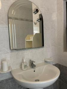La salle de bains est pourvue d'un lavabo blanc et d'un miroir. dans l'établissement Le 3 isole, à Marsaskala