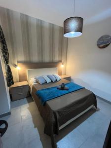 ein Schlafzimmer mit einem großen Bett mit einer blauen Decke in der Unterkunft Serenity Sea-view Maisonette in Marsalforn