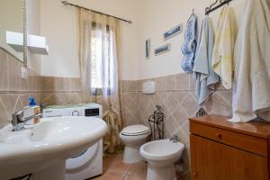 a bathroom with a white sink and a toilet at Casa Michela in Viddalba +14 photos