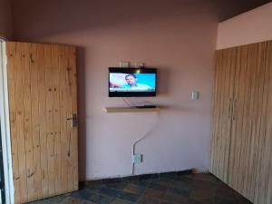 a television on a wall in a room at Lagai Roi Guesthouse in Boshoek