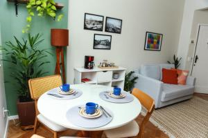 uma sala de estar com uma mesa branca e cadeiras em Aconchego no coração de Santa Teresa no Rio de Janeiro