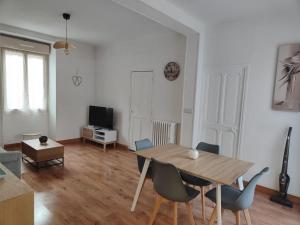 a living room with a wooden table and chairs at Maison de village à maligny 89 in Maligny