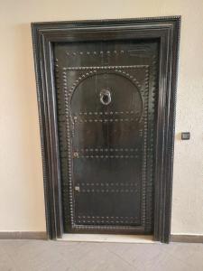 eine schwarze Tür in der Ecke eines Zimmers in der Unterkunft Nouvel Appartement Hamria in Meknès