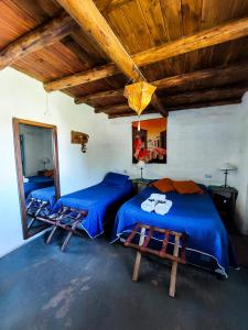 a bedroom with two beds and a wooden ceiling at La Casa de Vero in Cachí