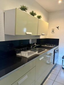 a kitchen with white cabinets and a sink at Ocean Lovers Apartamentos in Taganga